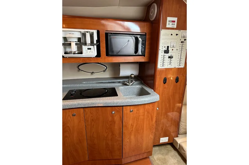 Slide: The Image of 2005 Larson Cabrio 310 yacht interior kitchen with microwave, sink, and control panel. - 6