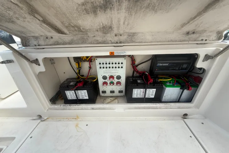 Slide: The Image of 2011 Robalo R305 Walkaround boat battery compartment with wiring and control panel. - 16