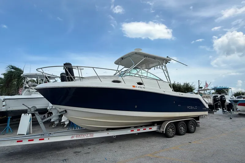 The Image of 2011 Robalo R305 Walkaround boat on trailer under blue sky. - 1