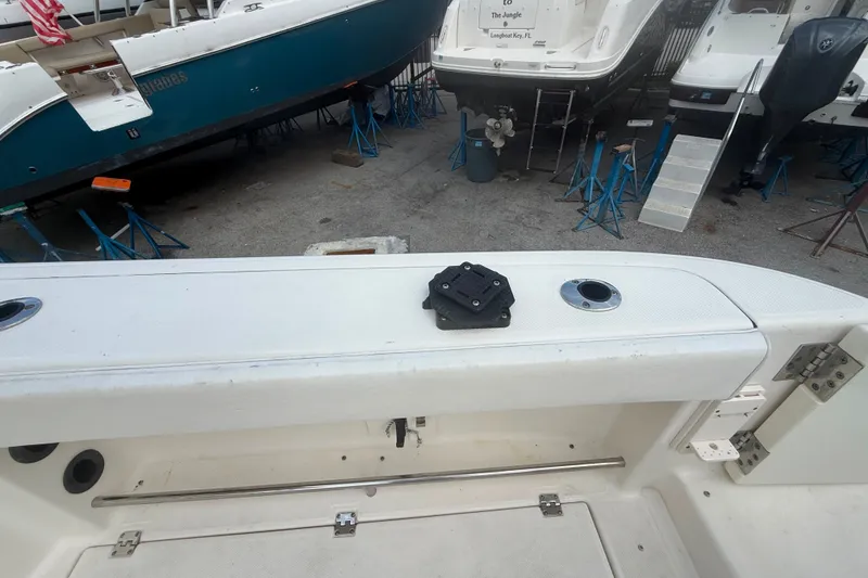 Slide: The Image of 2011 Robalo R305 Walkaround boat in dry dock, showcasing deck and surrounding vessels. - 20