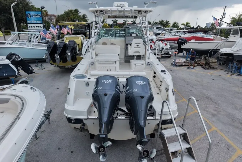 Slide: The Image of 2011 Robalo R305 Walkaround boat with twin Yamaha engines in a marina setting. - 7