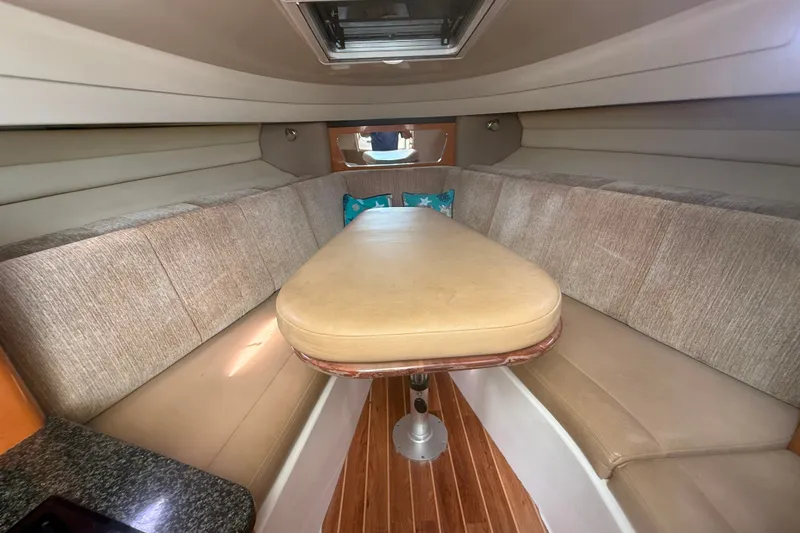 Slide: The Image of 2011 Robalo R305 Walkaround cabin interior with cushioned seating and wooden flooring. - 43