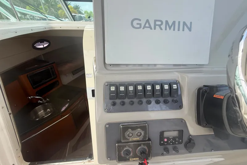 Slide: The Image of 2011 Robalo R305 Walkaround boat interior with Garmin navigation and control panel. - 34