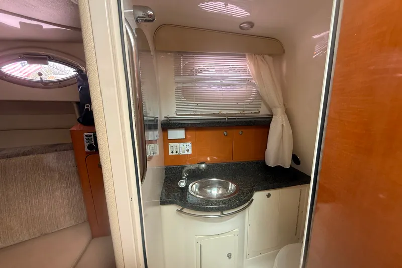 Slide: The Image of 2011 Robalo R305 Walkaround cabin interior with sink, countertop, and window blinds. - 46