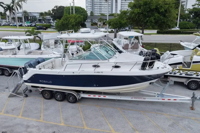 Slide: The Image of 2011 Robalo R305 Walkaround boat on trailer, parked in a marina lot. - 9
