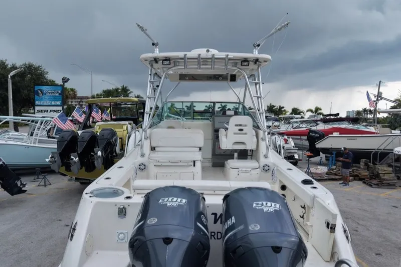 Slide: The Image of 2011 Robalo R305 Walkaround boat with dual Yamaha engines, docked under stormy skies. - 30