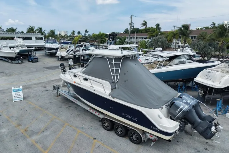 Slide: The Image of 2011 Robalo R305 Walkaround boat on trailer in marina with other boats. - 3