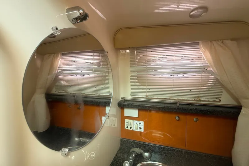 Slide: The Image of Interior of 2011 Robalo R305 Walkaround boat bathroom with mirror and window blinds. - 49