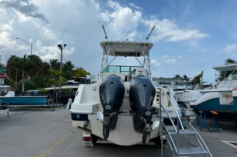 Slide: The Image of 2011 Robalo R305 Walkaround boat with twin outboard engines, parked outdoors. - 12