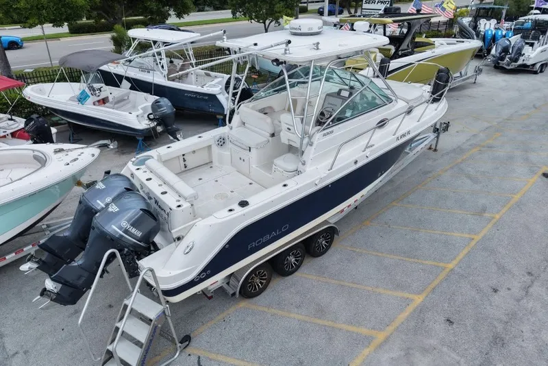Slide: The Image of 2011 Robalo R305 Walkaround boat with dual Yamaha engines, parked on a trailer. - 10