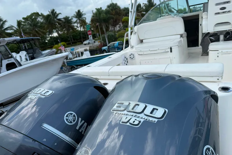 Slide: The Image of 2011 Robalo R305 Walkaround boat with Yamaha 300 V6 engines, docked near palm trees. - 17