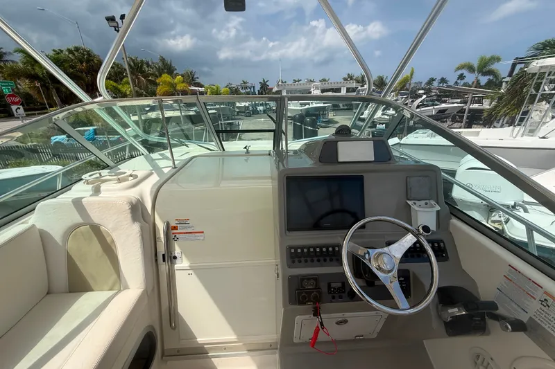 Slide: The Image of 2011 Robalo R305 Walkaround boat cockpit with steering wheel and control panel. - 33