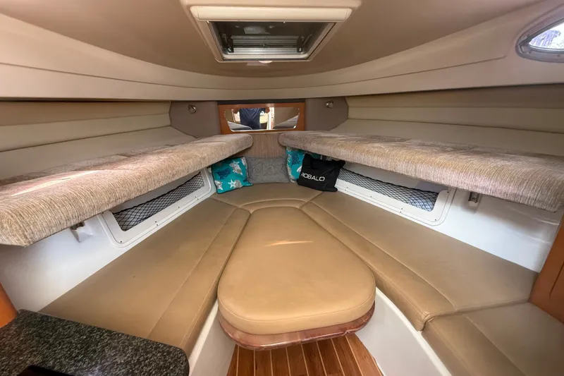 Slide: The Image of 2011 Robalo R305 Walkaround cabin interior with beige seating and overhead storage. - 41