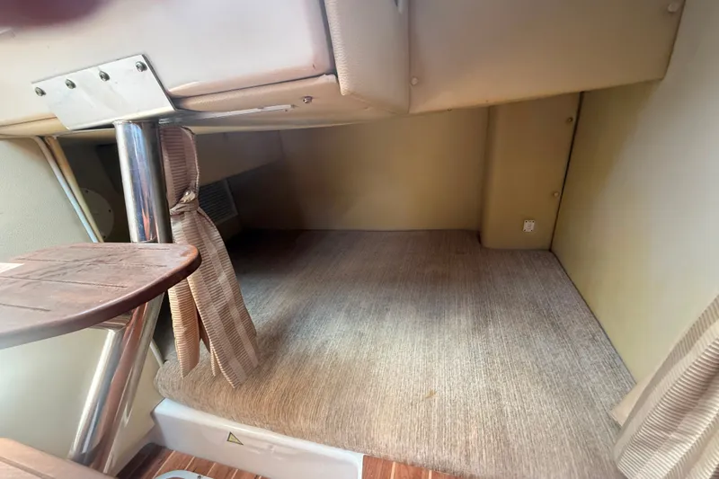 Slide: The Image of 2011 Robalo R305 Walkaround cabin interior with carpeted flooring and wooden table. - 36