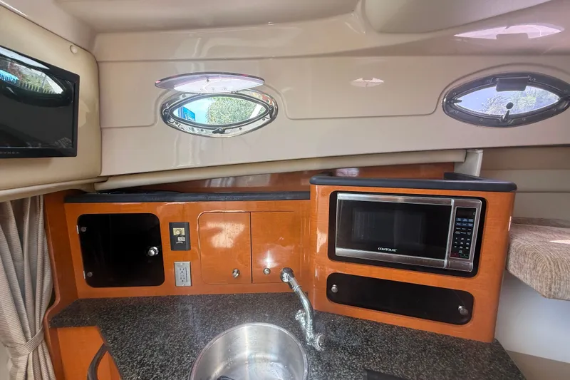 Slide: The Image of Interior of 2011 Robalo R305 Walkaround boat featuring kitchenette with microwave and sink. - 37