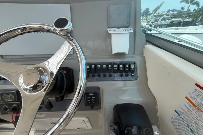 Slide: The Image of 2011 Robalo R305 Walkaround helm with steering wheel and control panel. - 29