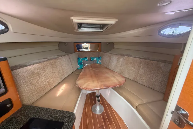 Slide: The Image of 2011 Robalo R305 Walkaround cabin interior with seating and wooden table. - 42