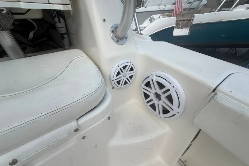 Slide: The Image of 2011 Robalo R305 Walkaround boat interior with white seating and dual speakers. - 21