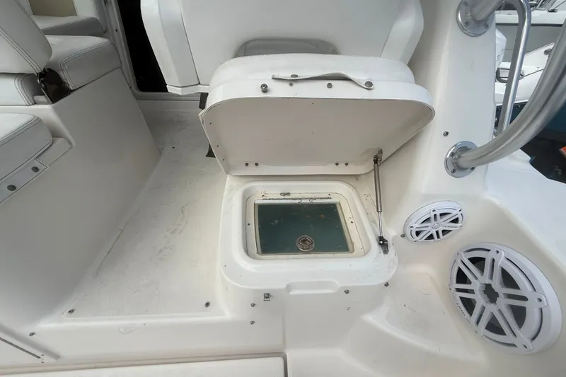 Slide: The Image of 2011 Robalo R305 Walkaround boat interior with open storage compartment and speakers. - 26