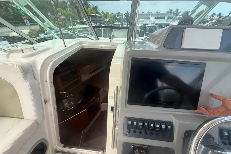 Slide: The Image of 2011 Robalo R305 Walkaround boat interior with Garmin display and cabin entrance. - 32