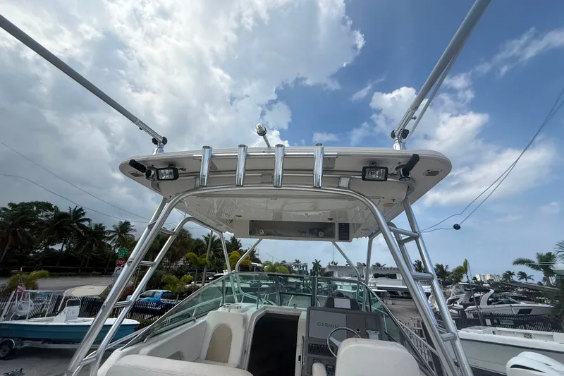 Slide: The Image of 2011 Robalo R305 Walkaround boat with T-top and fishing rod holders under a cloudy sky. - 19