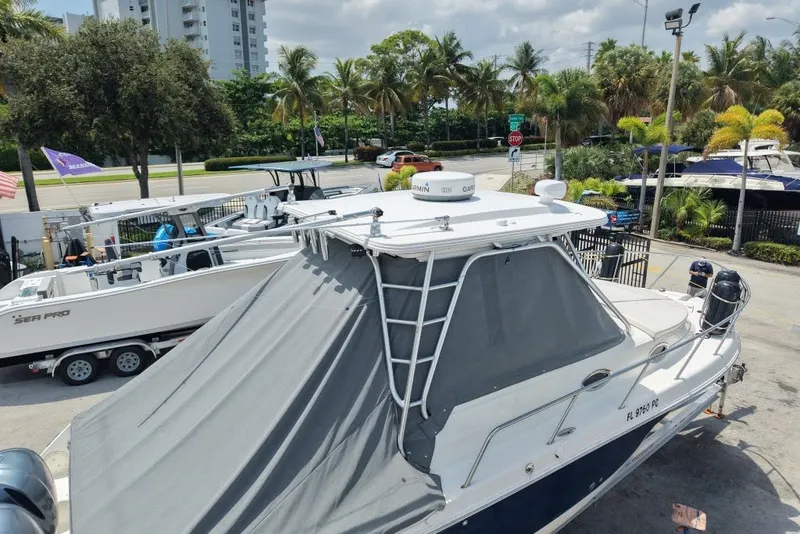 Slide: The Image of 2011 Robalo R305 Walkaround boat with canopy in a marina setting. - 5