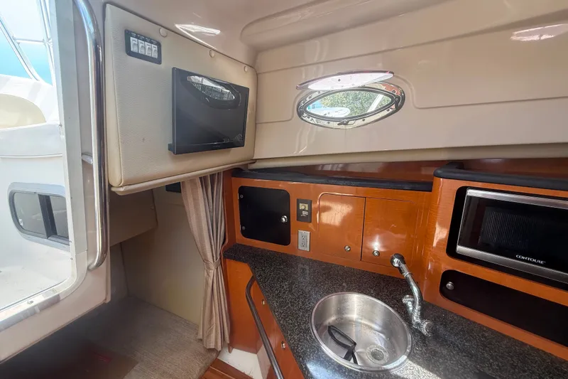 Slide: The Image of 2011 Robalo R305 Walkaround cabin with kitchenette, sink, and microwave. - 38