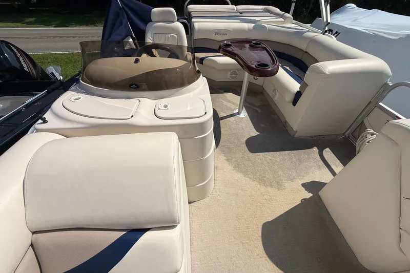 Slide: The Image of 2006 Triton Summit Pontoon 220 T Platinum interior with beige seating and steering console. - 27