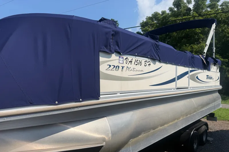 Slide: The Image of 2006 Triton Summit Pontoon 220 T Platinum with blue cover on trailer. - 3