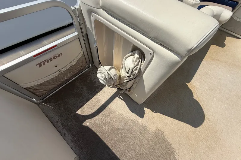Slide: The Image of 2006 Triton Summit Pontoon 220 T Platinum interior with storage compartment and coiled rope. - 10