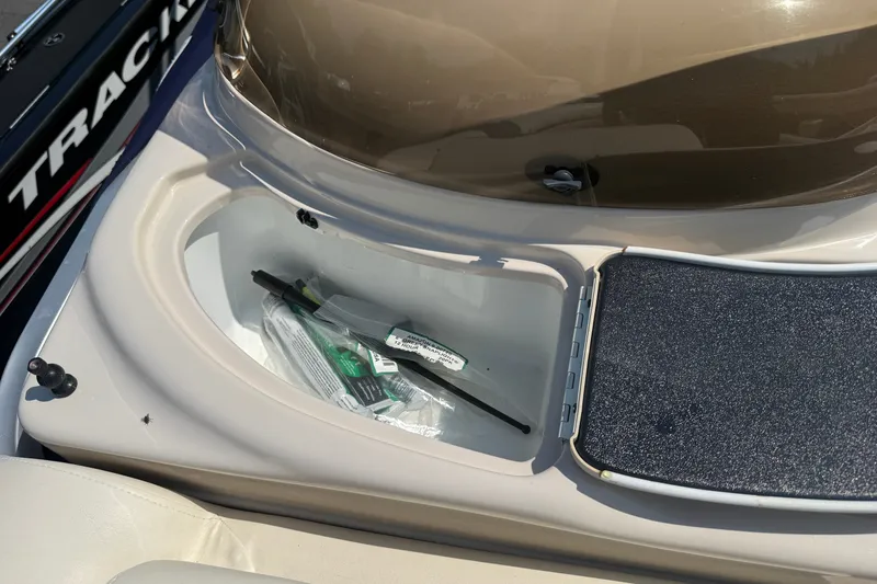 Slide: The Image of Storage compartment on 2006 Triton Summit Pontoon 220 T Platinum boat, containing various items. - 25