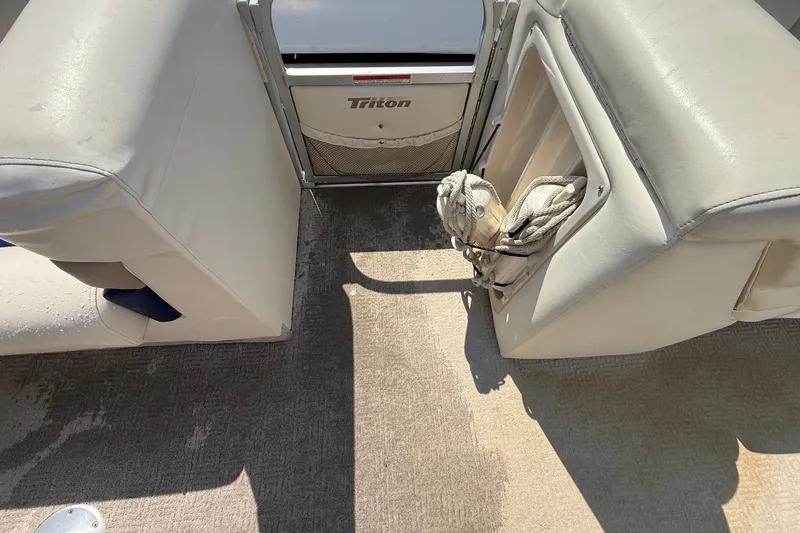 Slide: The Image of Interior of 2006 Triton Summit Pontoon 220 T Platinum with beige seating and storage. - 9