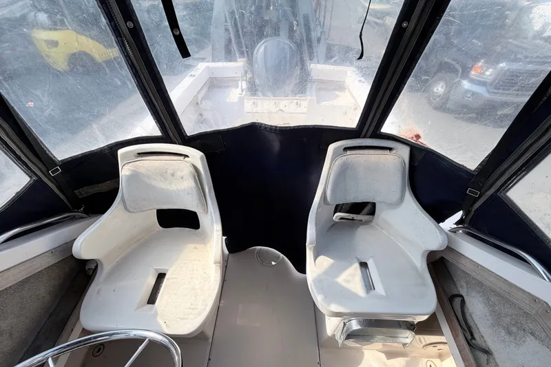 Slide: The Image of 1993 Grady-White Seafarer 22 boat interior with two white seats and clear canopy. - 8