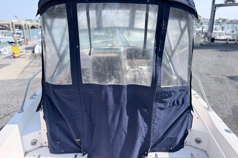 Slide: The Image of 1993 Grady-White Seafarer 22 boat with blue canvas enclosure at marina. - 6