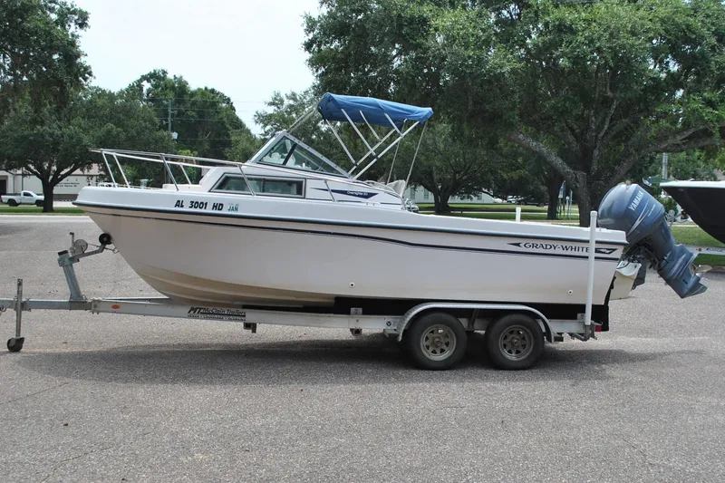 Slide: The Image of 1988 Grady-White Overnighter 20 boat on trailer, parked outdoors with trees in background. - 2