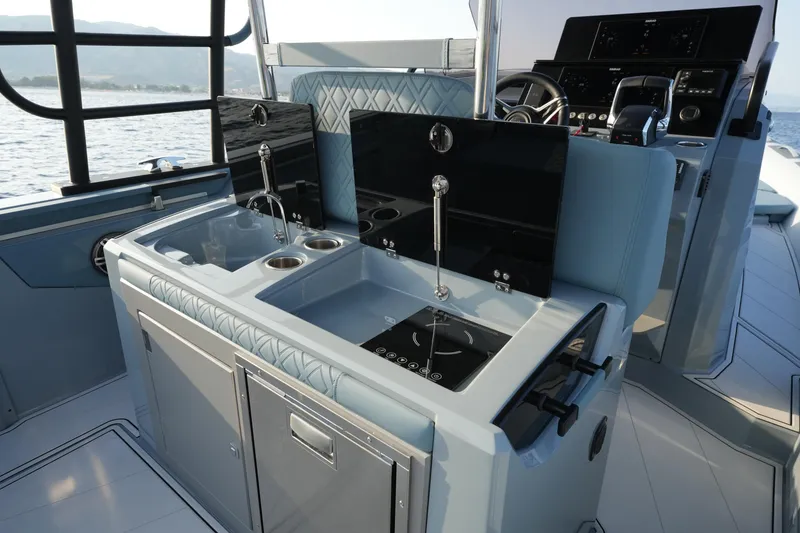 Slide: The Image of 2025 Ranieri Cayman 33 Executive yacht interior with modern kitchen and steering console. - 19