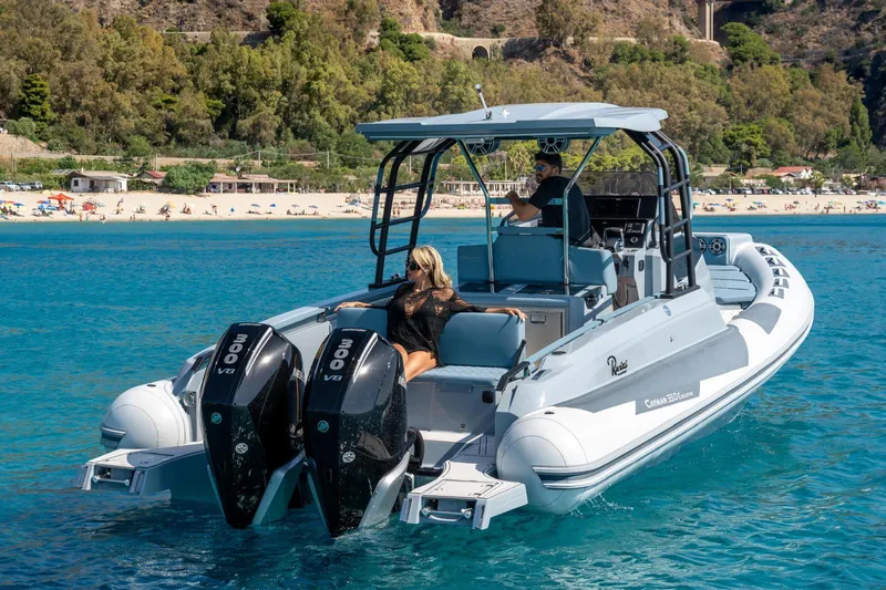 Slide: The Image of 2025 Ranieri Cayman 33 Executive boat cruising near a scenic beach. - 6