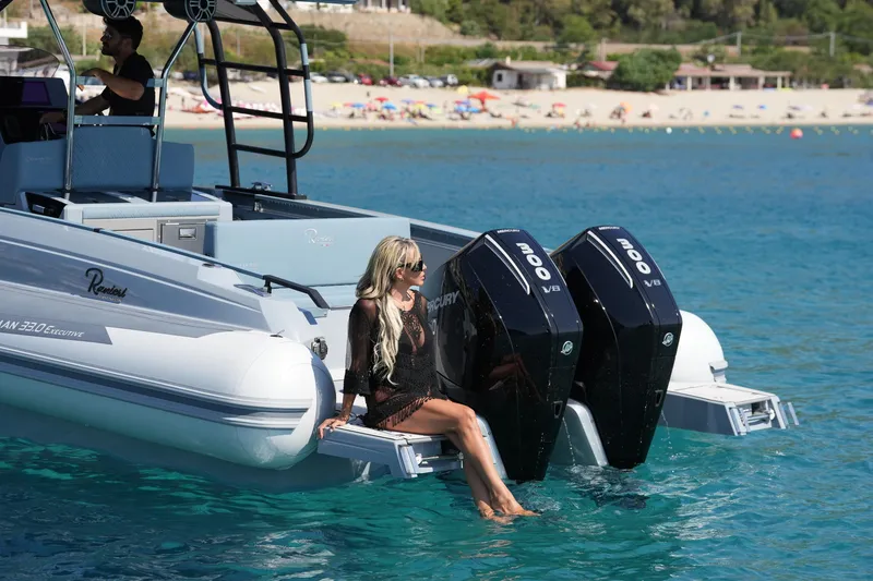 Slide: The Image of 2025 Ranieri Cayman 33 Executive boat with twin Mercury outboard engines on clear blue water. - 9