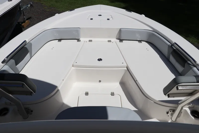 Slide: The Image of 2027 Robalo 226 Cayman boat interior with cushioned seating and storage compartments. - 24