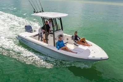 Slide: The Image of 2027 Robalo 226 Cayman boat cruising on clear water with passengers enjoying the ride. - 11