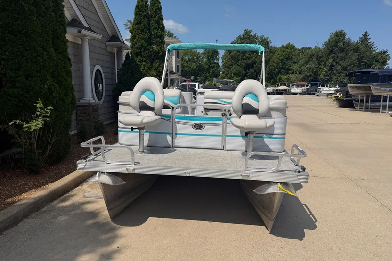 Slide: The Image of Pontoon boat Quest Edge 820, 2020 model, parked on concrete near trees and buildings. - 2