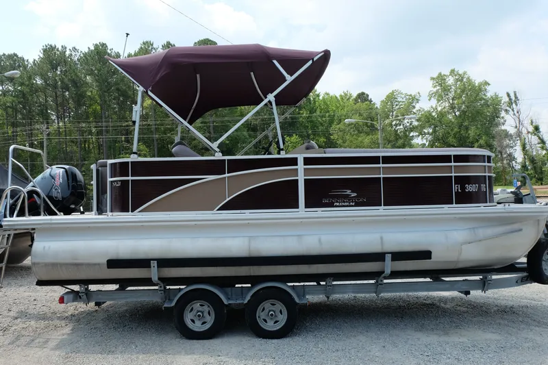 The Image of 2018 Bennington 21 SLXP pontoon boat with maroon canopy on a trailer. - 1