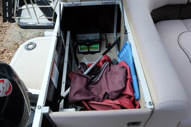 Slide: The Image of Storage compartment of a 2018 Bennington 21 SLXP boat with various items inside. - 18