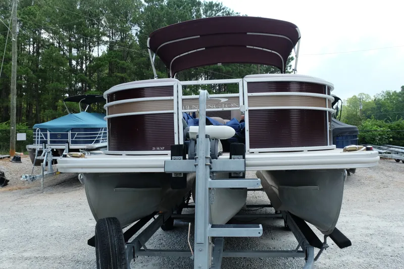Slide: The Image of 2018 Bennington 21 SLXP pontoon boat on trailer, surrounded by trees. - 3