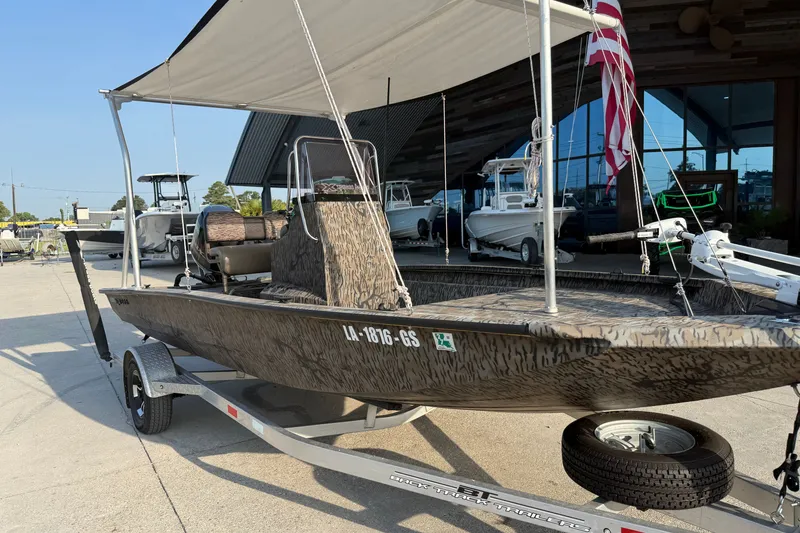 Slide: The Image of 2024 Xpress H190B Bay boat on trailer, featuring camouflage design and canopy. - 4