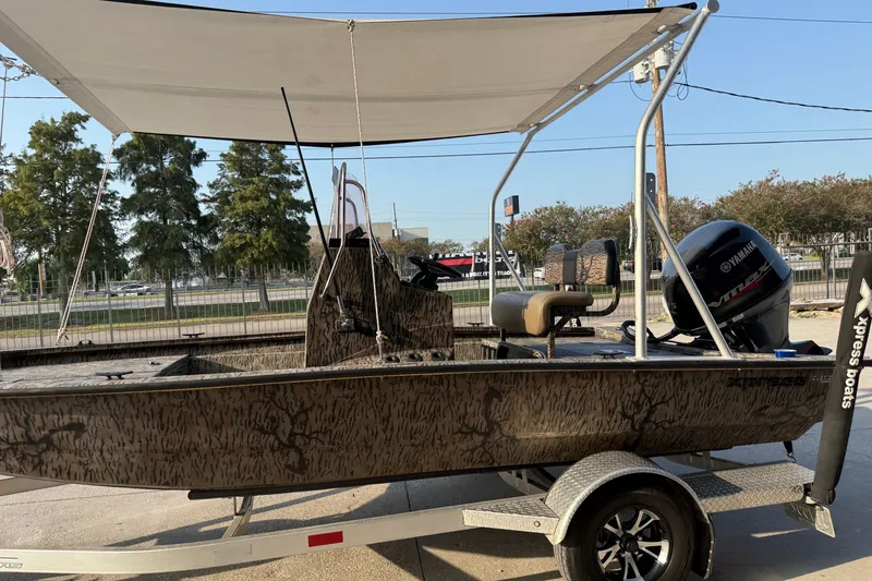 Slide: The Image of 2024 Xpress H190B Bay boat with canopy and Yamaha outboard motor on trailer. - 9