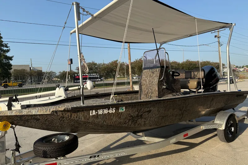 Slide: The Image of 2024 Xpress H190B Bay boat on trailer with canopy, parked outdoors. - 7