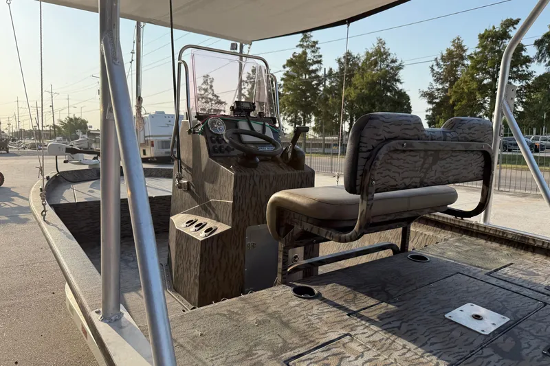 Slide: The Image of 2024 Xpress H190B Bay boat interior with console and seating, parked outdoors. - 11