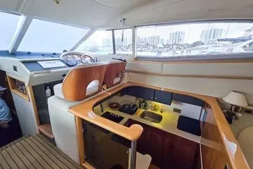 Slide: The Image of 1998 Viking Princess 56 Sport Cruiser interior with helm and galley, featuring modern amenities. - 24
