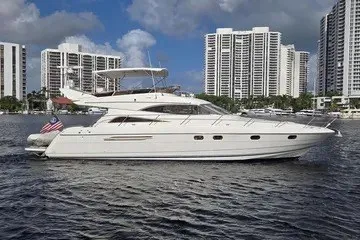Slide: The Image of 1998 Viking Princess 56 Sport Cruiser yacht on water with city skyline backdrop. - 2